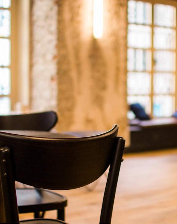A row of chairs are in a room with a large window.