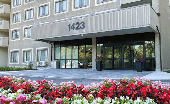 A large building with a lot of windows is surrounded by trees.