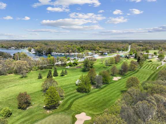 A golf course with a lake in the distance.