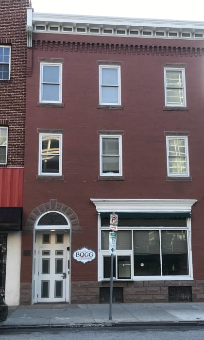 a red brick building with a white door and a street sign