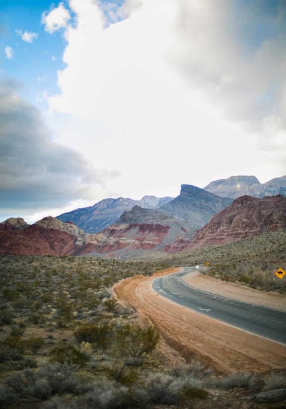 a road through the desert with mountains in the background