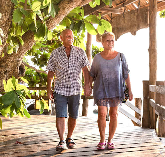 a man and a woman walking on a wooden bridge at Gateway Club, Boynton Beach, Florida