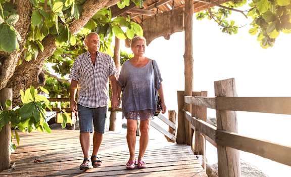 a man and a woman walking on a wooden bridge at Cypress Shores, Coconut Creek, Florida