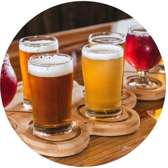 a selection of beers and cocktails on a wooden table