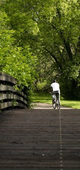 a man riding a bike down a bridge