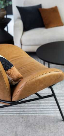 A brown leather chair with a black metal frame.
