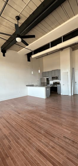 A room with wooden floors and a ceiling fan.