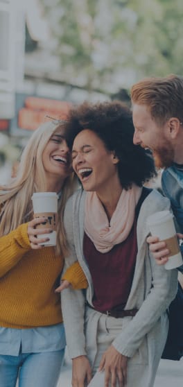 a group of people laughing and holding cups of coffee