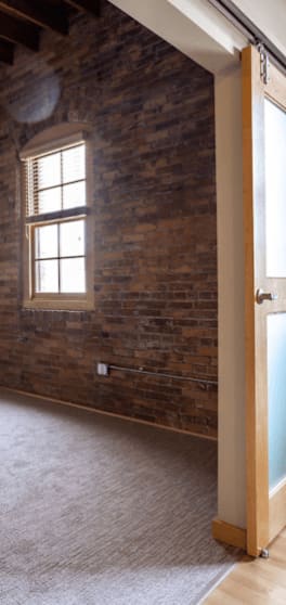 an empty room with a brick wall and a window