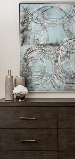 a large painting on a wall above a wooden dresser at The Summit at Owings Mills Apartments, Maryland, 21117