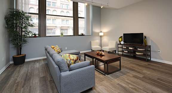 A living room with a grey couch and a wooden coffee table.