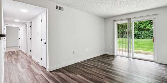 A room with a sliding glass door leading to a backyard.