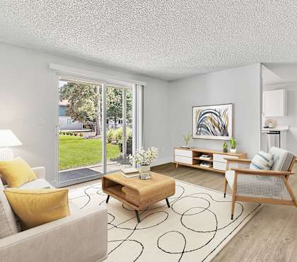 A living room with a grey couch, yellow pillows, a wooden coffee table, and a painting on the wall.