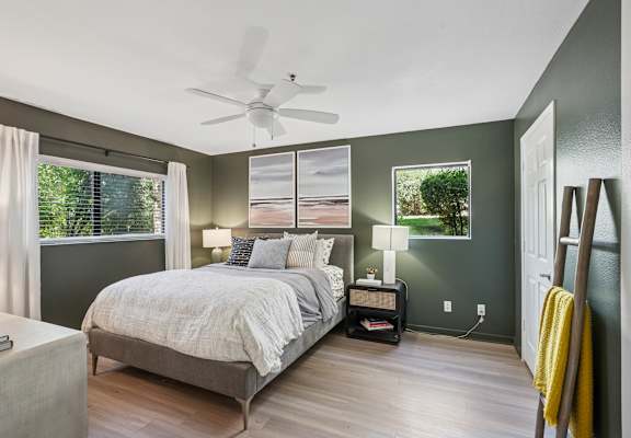 A bedroom with a large bed and a ceiling fan.