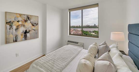 A bedroom with a large bed and a painting on the wall.