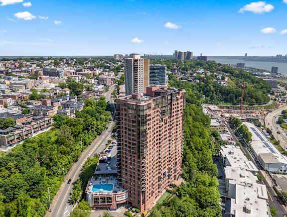 A tall red brick building stands in the middle of a city.