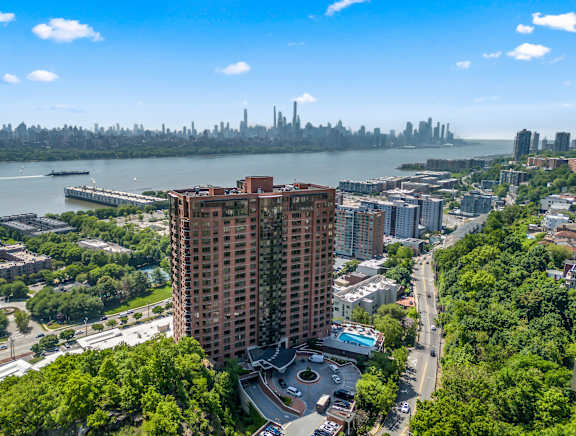 A tall red building is in the center of a cityscape.