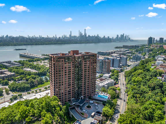 A tall red building is in the center of a cityscape.