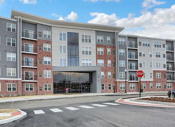 an apartment building on a street corner with a stop sign