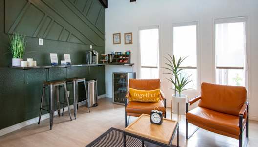 A living room with a green wall and a couch.