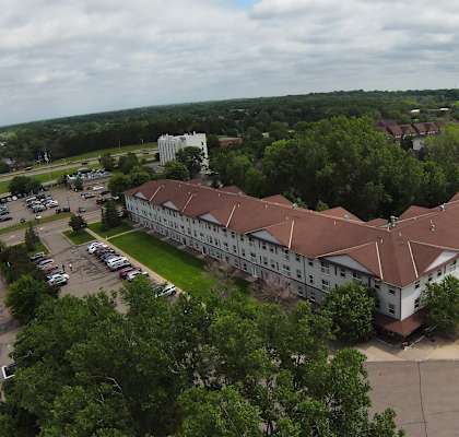 a large building with a brown roof next to a parking lot
