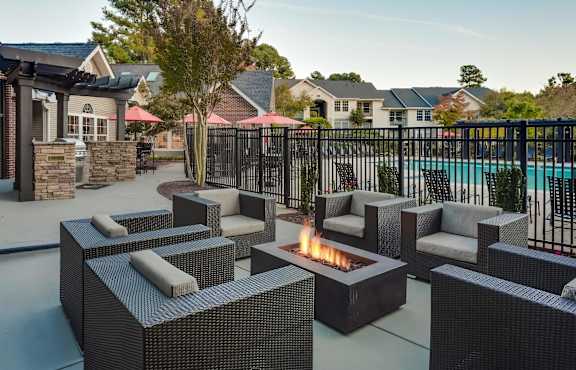 a patio with chairs and a fire pit near a pool at Midtown Crossing in North Carolina 27609