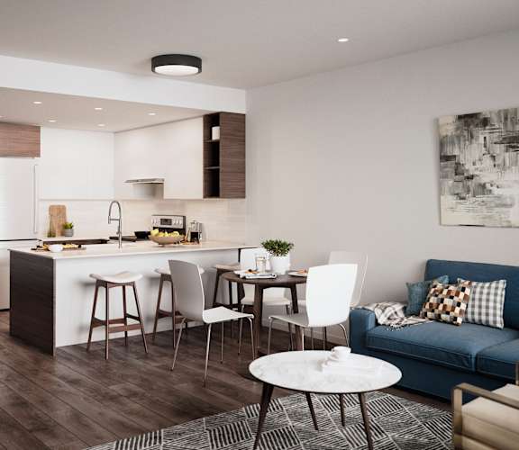 A modern kitchen with a dining table and chairs is adjacent to a living room with a couch and a coffee table.