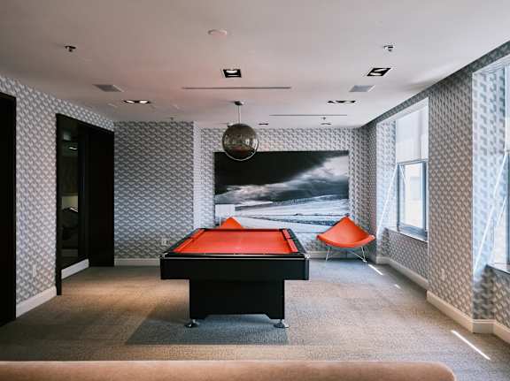 A room with a pool table and a chair.