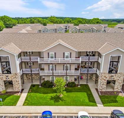 A large apartment complex with a green lawn in front.