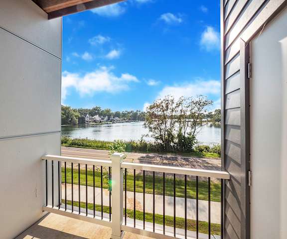 A balcony with a view of a river and trees.