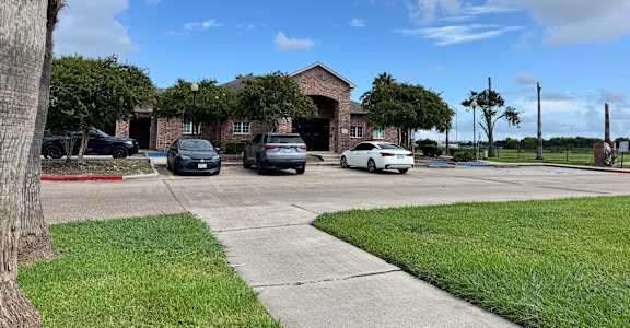 A parking lot with cars and a building in the background.