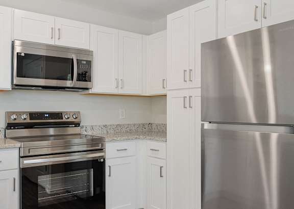 a kitchen with white cabinets and a granite counter top