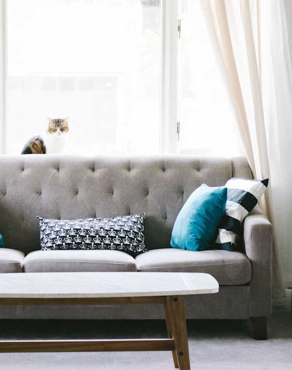A room with a white door and a window with a grey floor.