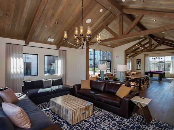 A large, open-concept living room with wooden beams and a variety of seating options.