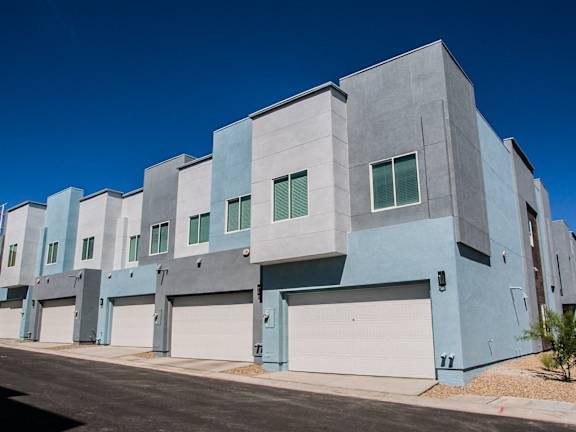 the exterior of a building with white and blue doors