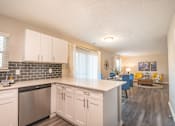 Thumbnail 3 of 8 - A kitchen with white cabinets and a stainless steel dishwasher.