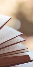 a stack of open books on a table