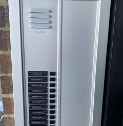 a photograph of the exterior of a door to a home with an air conditioning unit on the