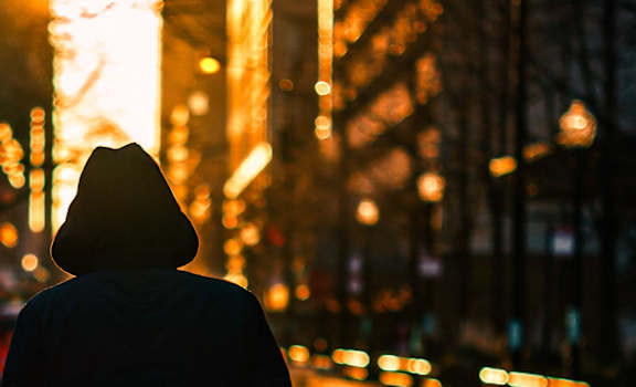 Person standing on a city street at sunset  at Charbonneau Apartments in Seattle, WA 98101