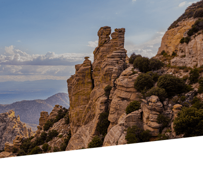 A mountain range with rock formations and trees.