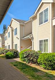 A row of houses with a sidewalk in front.