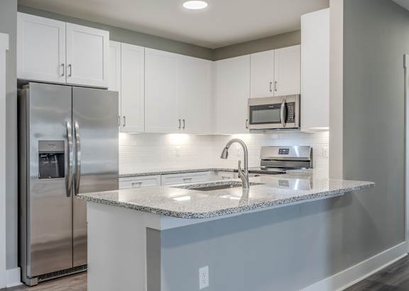 a kitchen with white cabinets and a granite counter top
