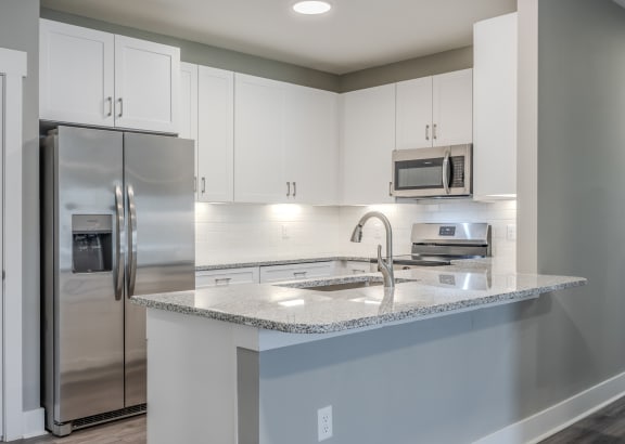a kitchen with white cabinets and a granite counter top