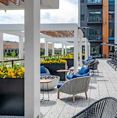 A patio with chairs and tables is covered with a white roof.
