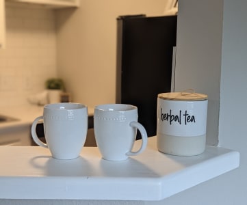a kitchen with white mugs that say happy tea