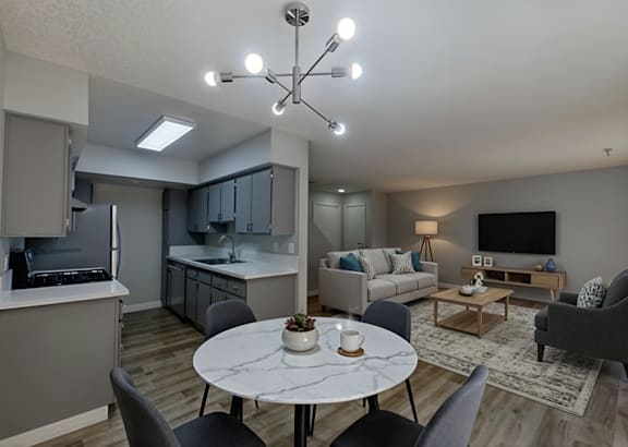 a kitchen with black cabinets and stainless steel appliances and a white counter top
