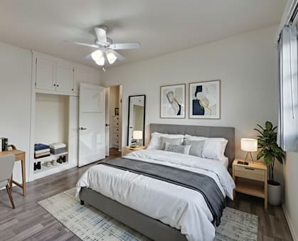 A bedroom with a bed, desk, and chair.