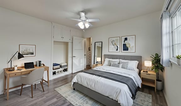 A bedroom with a bed, desk, and chair.