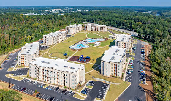 an aerial view of an apartment complex with buildings and a parking lot