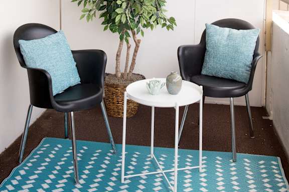 A living room with a blue rug and two chairs at Hampton Plaza Apartments, Towson, MD, 21286